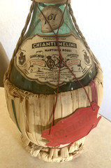 1951 Chianti Melini empty wine bottle, in wicker basket, with import stamp