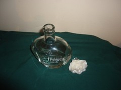 JNSQ Rose CRU glass bottle with white rose stopper, 10” tall, 5.75” wide. EMPTY