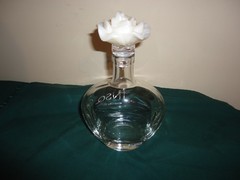 JNSQ Rose CRU glass bottle with white rose stopper, 10” tall, 5.75” wide. EMPTY