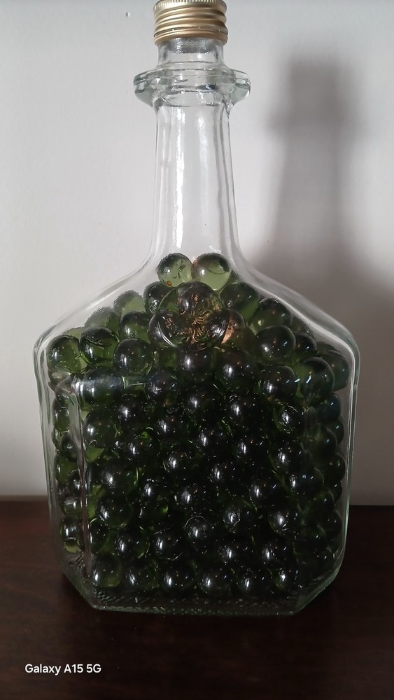Vintage Glass Wine Bottle With Embossed Design Full of Green Marbles