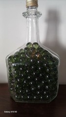 Vintage Glass Wine Bottle With Embossed Design Full of Green Marbles