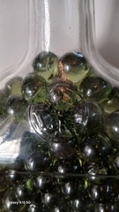 Vintage Glass Wine Bottle With Embossed Design Full of Green Marbles