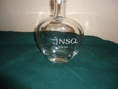 JNSQ Rose CRU glass bottle with white rose stopper, 10” tall, 5.75” wide. EMPTY