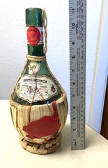 1951 Chianti Melini empty wine bottle, in wicker basket, with import stamp