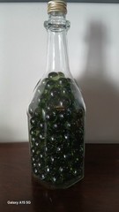 Vintage Glass Wine Bottle With Embossed Design Full of Green Marbles