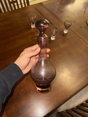 This Is A Vintage Wine Glass and A Bottle The Color Is Is Also Wine Red And Purp