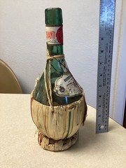 1951 Chianti Melini empty wine bottle, in wicker basket, with import stamp