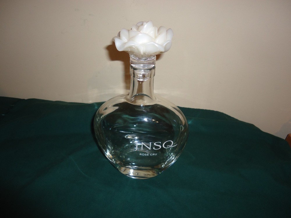JNSQ Rose CRU glass bottle with white rose stopper, 10” tall, 5.75” wide. EMPTY