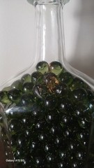 Vintage Glass Wine Bottle With Embossed Design Full of Green Marbles