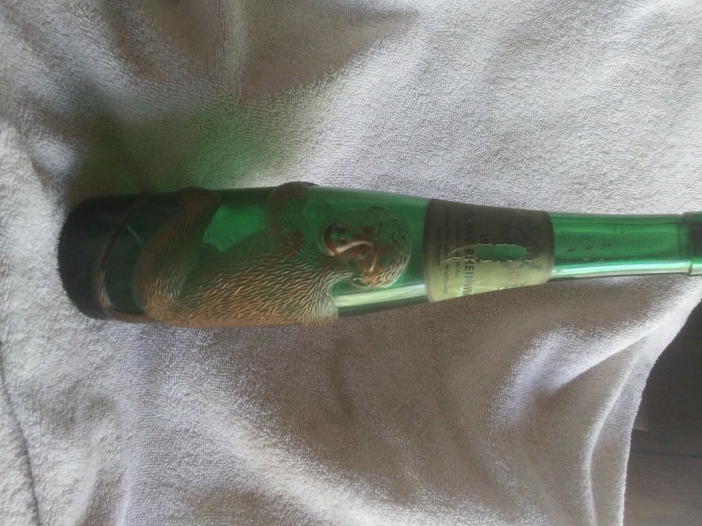 old German green wine bottle with gold embossed monkey wrapped around it